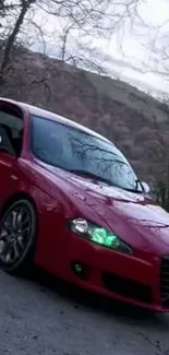 Red sports car parked with a scenic view.