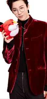 Person holding a plush toy in a red velvet jacket.