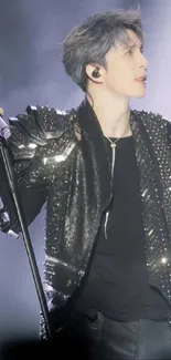 Stylish rockstar in black leather jacket on stage.