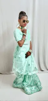 Young woman posing in mint green saree, stylish and elegant.