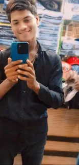 Young man takes a selfie in a clothing store, showcasing fashion style.