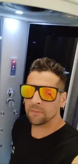 Man wearing reflective sunglasses taking a stylish selfie.