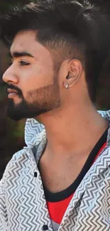 Stylish young man with trendy haircut and beard in profile.