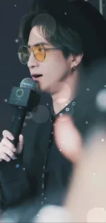 Stylish singer with sunglasses holding a microphone.