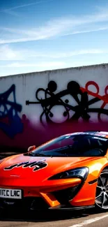 Orange sports car with graffiti art background on a sunny day.