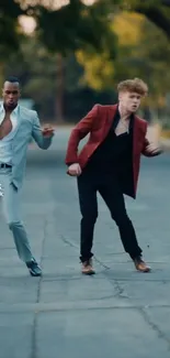 Energetic duo dancing in stylish suits on a city street.