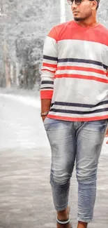 Man wearing striped shirt with jeans in fashion-forward pose.