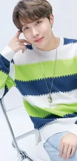 Person wearing a stylish striped sweater in blue and green.