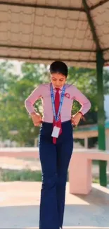 Student in stylish red and blue uniform under pavilion.