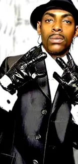 Man in black suit and gloves, striking a stylish pose.