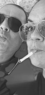 Monochrome portrait of two people wearing sunglasses with a stylish vibe.