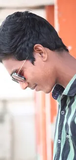 Young man in sunglasses with striped shirt, modern look.