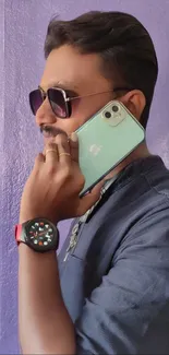 Man with sunglasses using a smartphone in a stylish and tech-forward setting.