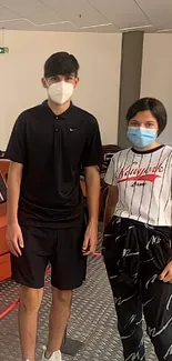 Teens in a garage with stylish outfits and face masks.