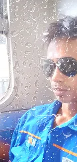 Person in blue shirt with sunglasses on train.