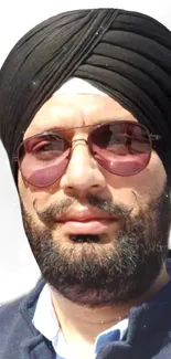 Portrait of a stylish man in a black turban and sunglasses.