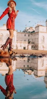 Stylish woman in red jacket reflects in water, urban setting.