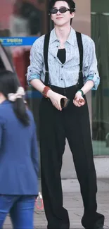 Young man in urban fashion with sunglasses and suspenders.