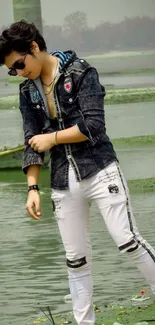 Fashionable figure by misty lake in denim jacket.