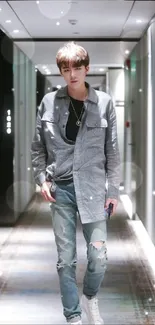 Person in a gray outfit in a stylish hallway setting.