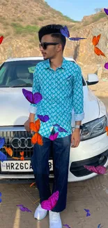 Person in blue shirt standing by white car with rugged hills landscape.