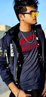 Young man in stylish blue jacket with yellow sunglasses outdoors.