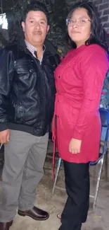 Two people posing in stylish urban attire outdoors.
