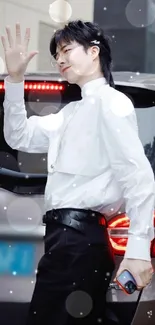 Fashionable individual in white shirt waving.