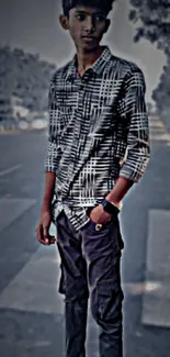 Young person posing on urban street in a stylish grayscale setting.