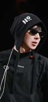 Hooded figure in sunglasses with urban fashion style.