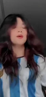 Woman wearing blue and white shirt with stylish hairstyle.
