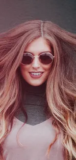 Woman with sunglasses and flowing hair in stylish mobile wallpaper.