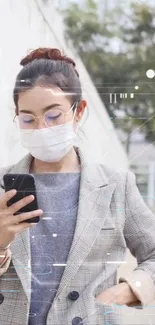 Woman in plaid blazer with phone in hand.