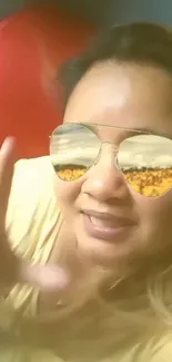 Woman wearing sunglasses reflecting sunflowers.