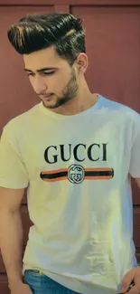 Young man in a Gucci t-shirt against a burgundy door background.