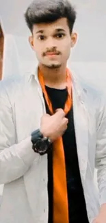 Young man in a stylish outfit with orange tie in modern setting.