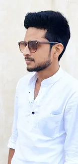 Young man in sunglasses and white shirt with light background.