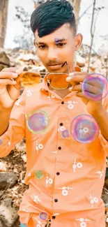 Youth in orange shirt holding sunglasses outdoors.