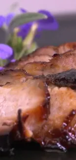 Succulent grilled meat with vibrant purple flowers.