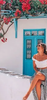 Greek island scene with blue door and vibrant flowers.