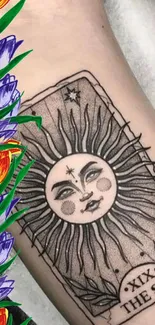 Sun tarot card tattoo with colorful floral accents.