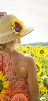 Woman in sunflower field wearing a sun hat on a bright sunny day.