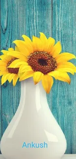 Sunflowers in a white vase against a teal wood background.