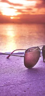 Sunglasses on a vibrant purple sunset beach.