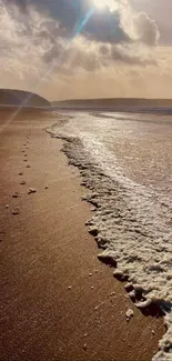 Sunlit beach with waves and serene horizon.