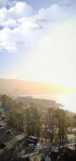 Coastal landscape with sunlight and clouds over lush greenery.