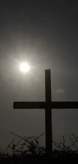 Silhouette of a cross with sunlight in the background.