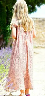 A young girl in a floral dress walking in a sunlit garden.