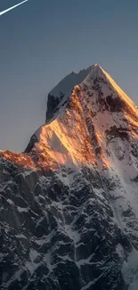 Sunlit mountain peak against blue sky wallpaper.