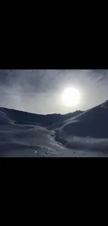 Snowy mountains under cloudy sky with sun shining.